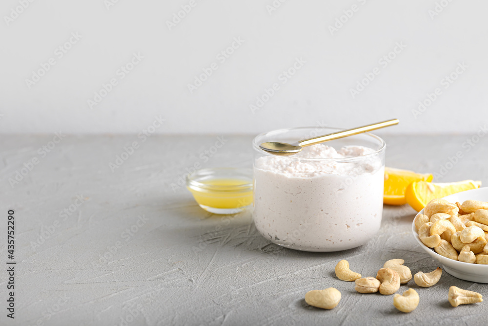 Bowl of sour cream with cashew nuts on light background Bowl of sour cream with cashew nuts on light background