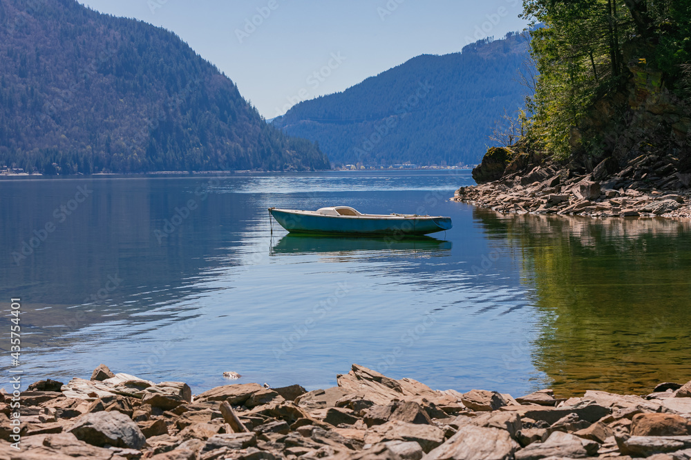 fishing boat docked in calm lake of a dreamy landscape with beautiful mountain in British Columbia.