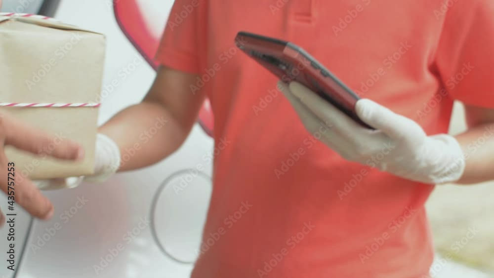 Hand of a man using QR code scanner with smartphone for a parcel payment. Delivery courier woman wearing rubber gloves holding a paper box for sending to customer at home. Paying on mobile technology. Hand of a man using QR code scanner with smartphone for a parcel payment. Delivery courier woman wearing rubber gloves holding a paper box for sending to customer at home. Paying on mobile technology.
