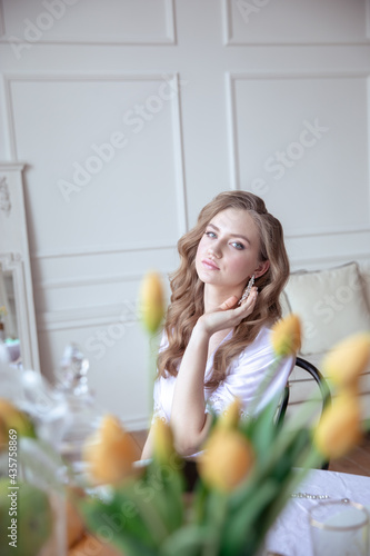 beautiful young girl in a white robe in a bright interior