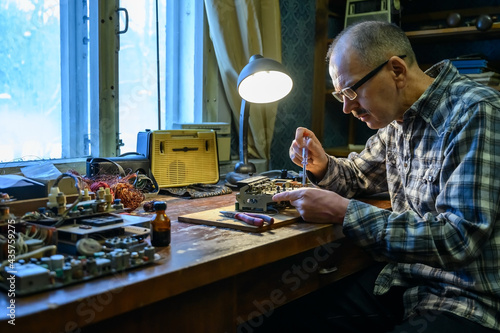 Foto Male amateur radio operator repairing an old radio receiver