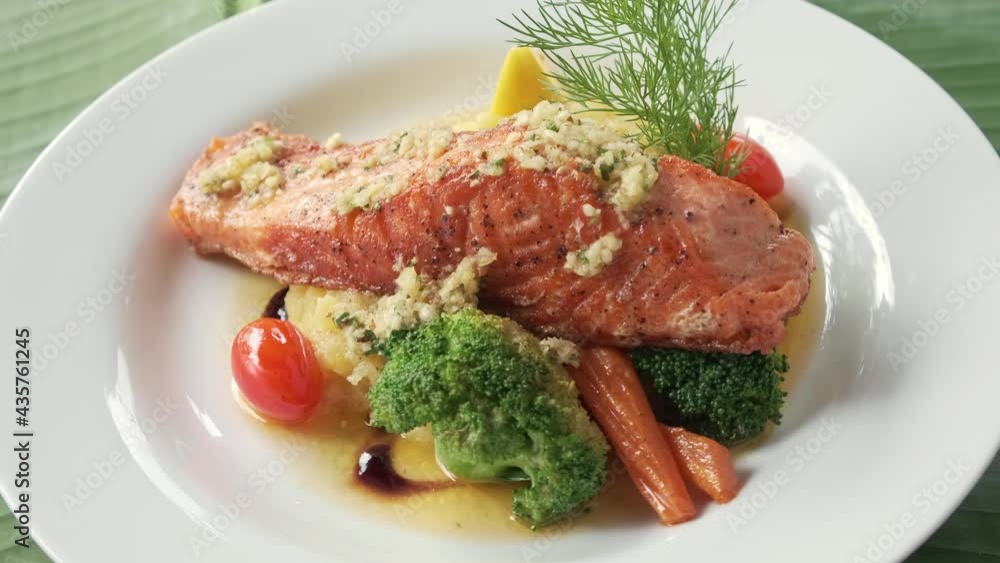 salmon steak with mashed potato,vegitables and lemon and dill, rotatating to the camera salmon steak with mashed potato,vegitables and lemon and dill, rotatating to the camera