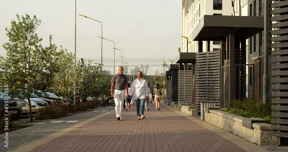 A married couple is walking down the street and holding hands. These are elderly people who walk, breathe air, stretch their legs and communicate with each other. They have lived a long life A married couple is walking down the street and holding hands. These are elderly people who walk, breathe air, stretch their legs and communicate with each other. They have lived a long life