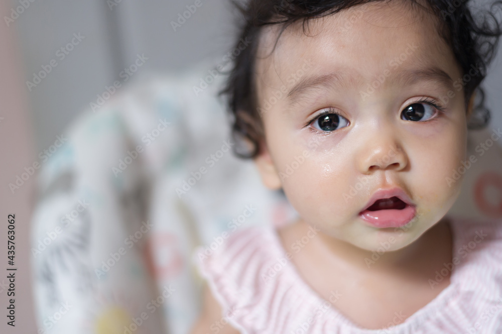 Close up at face of little cute Asian baby girl, looking at camera with copy space Close up at face of little cute Asian baby girl, looking at camera with copy space