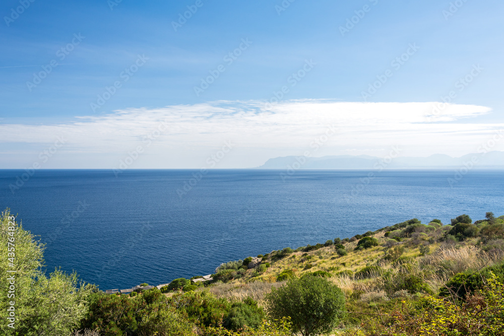 Beautiful blue ocean and typical Mediterranean vegetation in the Zingaro nature reserve at the coast of Sicily, Italy