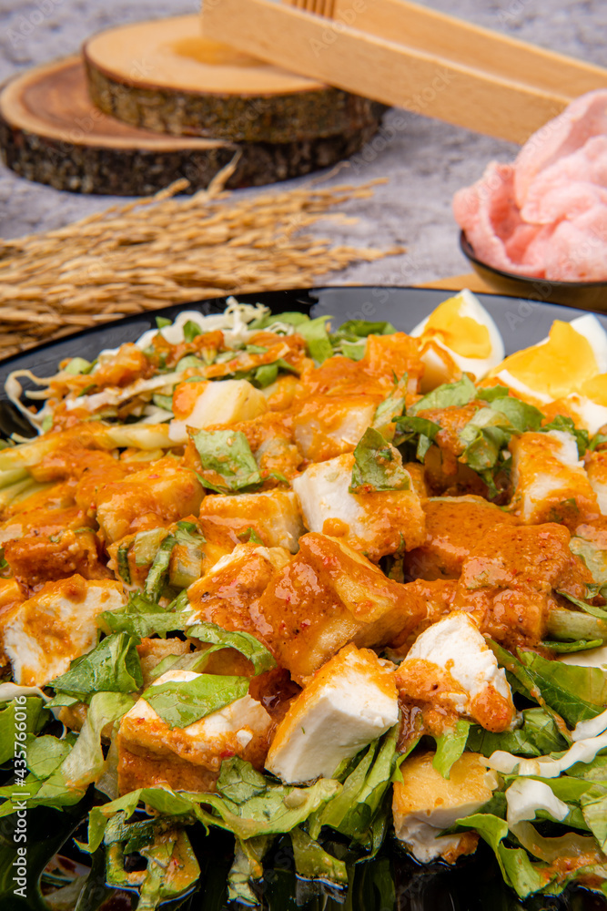 Gado Gado is an Indonesian salad of slightly boiled, blanched or steamed vegetables and hard-boiled eggs, boiled potato, fried tofu and tempeh, and lontong, served with a peanut sauce dressing.