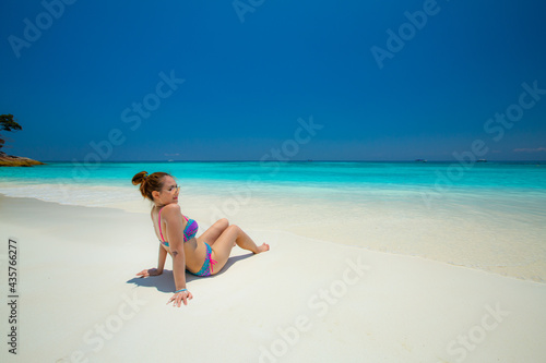 Woman in bikini Sunbathing on the white sandy beach on paradise island. In the Andaman Sea , Thailand