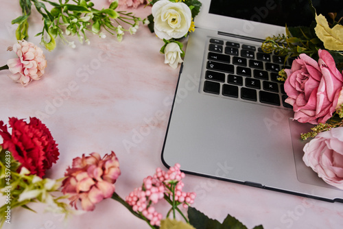 Computadora portátil con flores al rededor concepto femenino