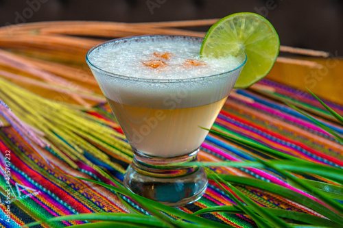 Traditional Peruvian pisco sour cocktail with a slice of lime