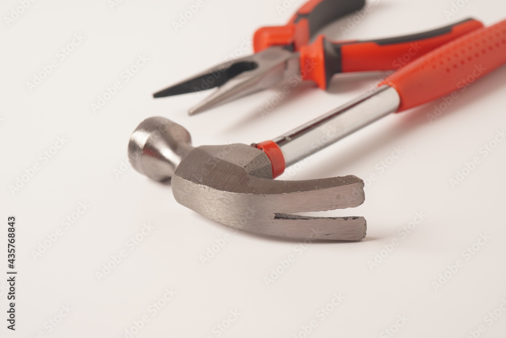 Hammer and Pliers on white background. Close up image of standard claw hammer and Needle Nose Pliers Hammer and Pliers on white background. Close up image of standard claw hammer and Needle Nose Pliers