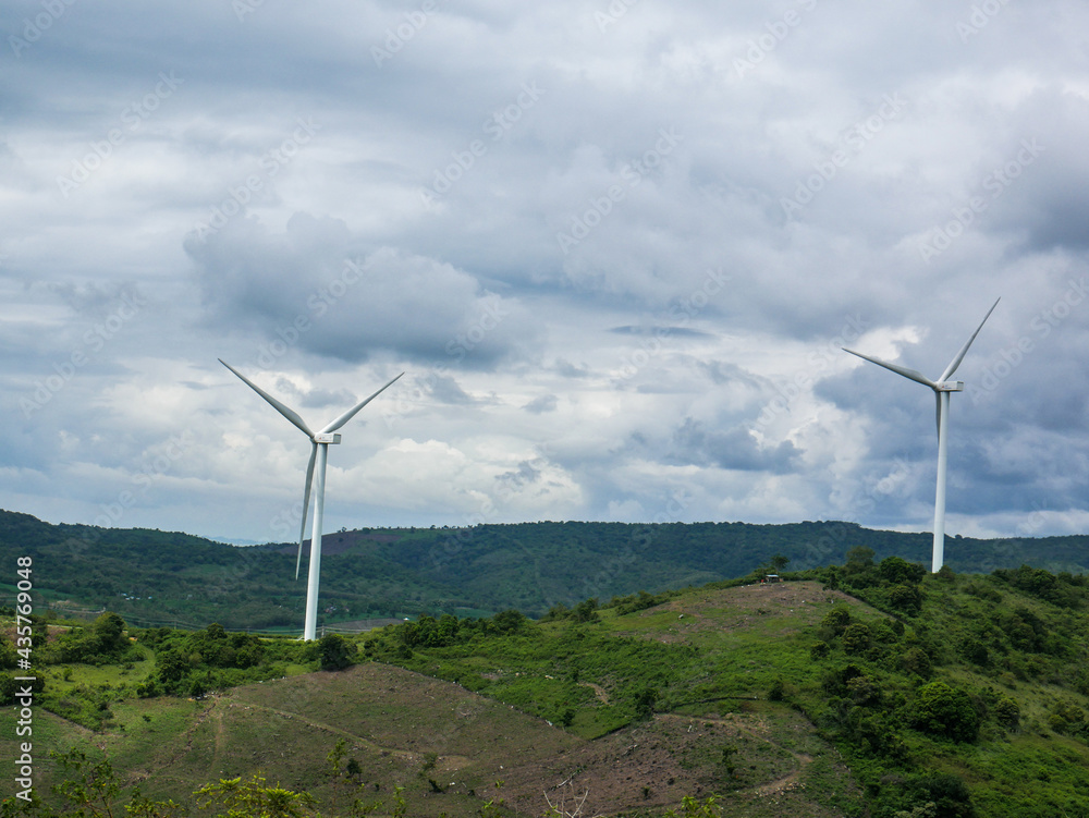 Wind turbines on the green hilly terrain with the bright blue sky. Wind turbines on the green hilly terrain with the bright blue sky.