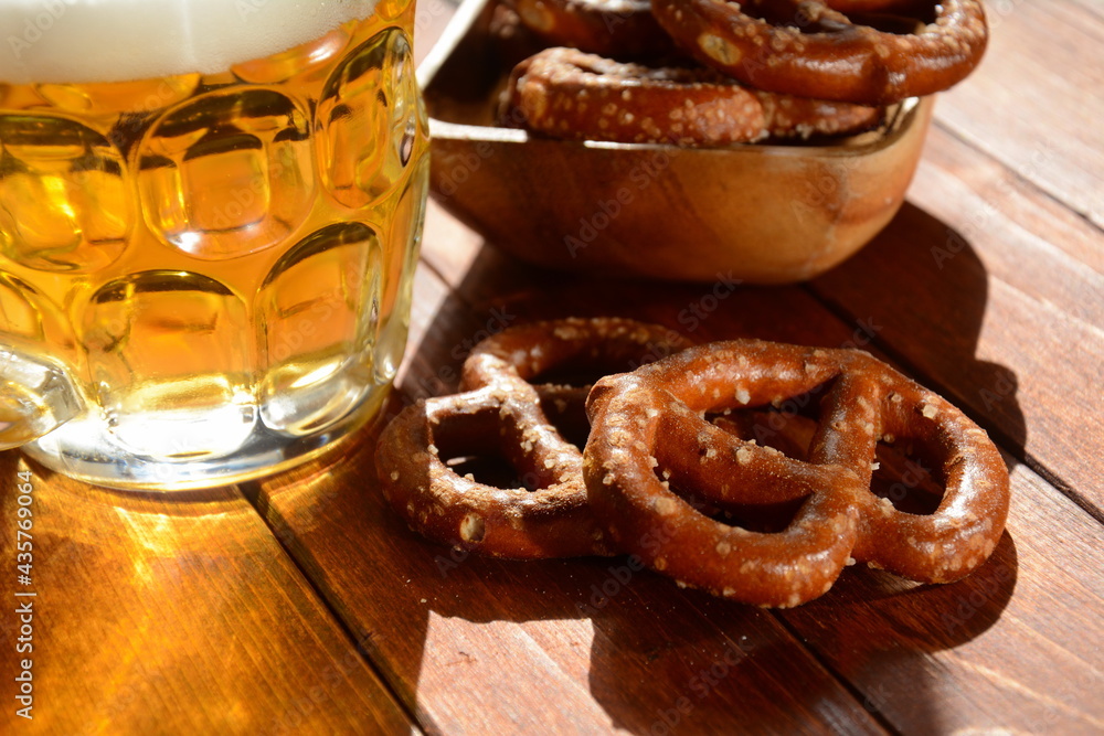 Hard Pretzels or Salted pretzels snack for party on rustic wooden table with glass of beer Hard Pretzels or Salted pretzels snack for party on rustic wooden table with glass of beer