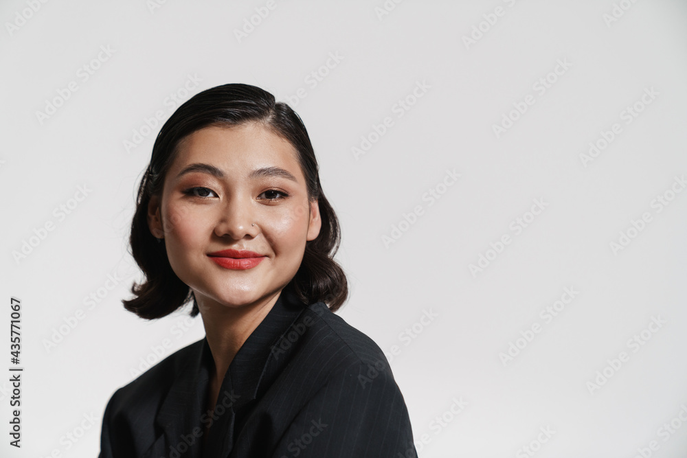 Brunette asian woman wearing jacket smiling at camera Brunette asian woman wearing jacket smiling at camera