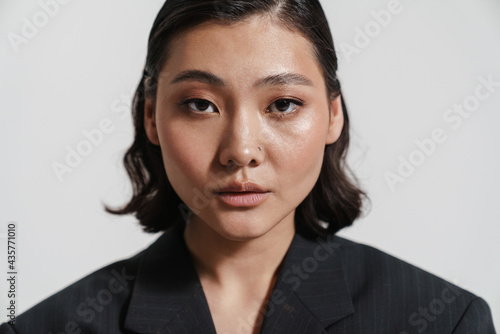 Brunette asian woman wearing jacket looking at camera