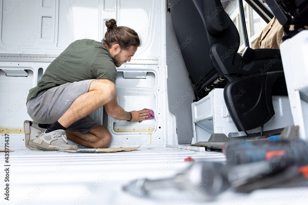 Fototapeta premium Man cleaning the inside of a van