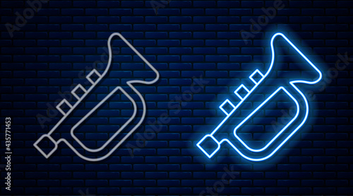 Glowing neon line Musical instrument trumpet icon isolated on brick wall background. Vector