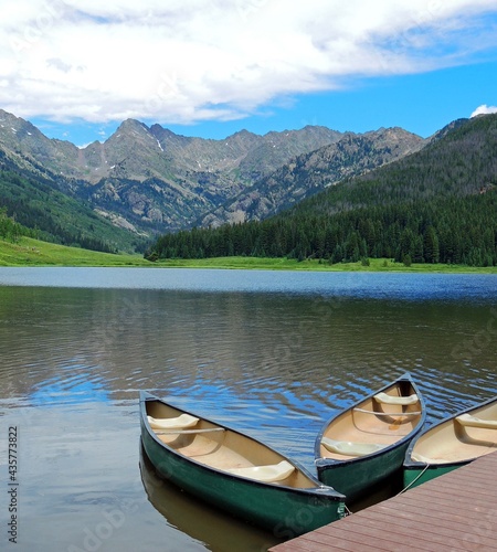 Tranquil scene of canoes in the summer at piney lake against a gore range mountain backdrop, near vail, colorado 