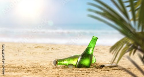 Fototapeta Naklejka Na Ścianę i Meble -  Fresh beer bottles in sand on a beach with palm