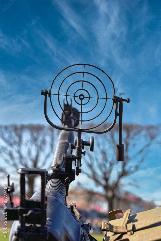fragment of an anti aircraft machine gun, a round sight is aimed at clouds sky