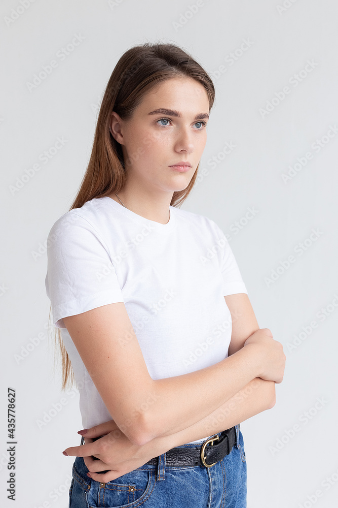 portrait of young attractive caucasian woman with long hair in t-shirt and blue jeans isolated on white studio background. skinny pretty female posing on cyclorama. model tests of beautiful lady portrait of young attractive caucasian woman with long hair in t-shirt and blue jeans isolated on white studio background. skinny pretty female posing on cyclorama. model tests of beautiful lady