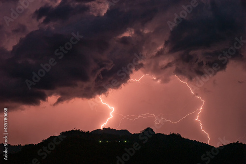 On the mountain peak, when there is rain, storm and thunder, the hilltop village at night with lightning in the summer