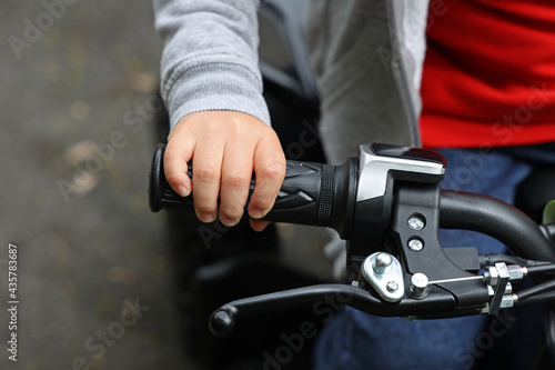 Childs hand on the steering wheel of a quad