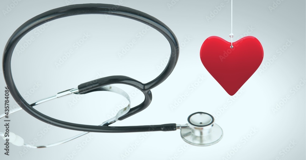 Composition of red hanging heart and stethoscope with copy space on white background Composition of red hanging heart and stethoscope with copy space on white background