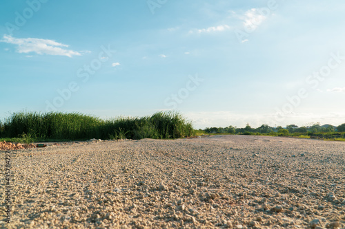 A lonely dirt road in a rural field with sunset summer sky background. copy space for text.