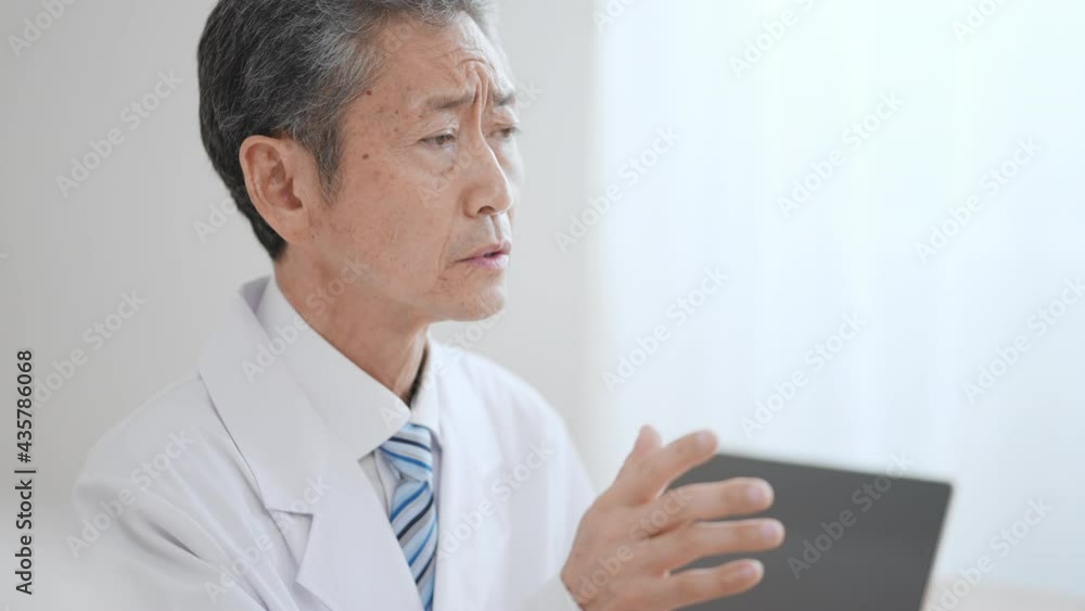 高齢の男性医師 険しい表情 高齢の男性医師 険しい表情