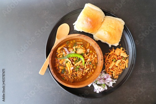 Spicy Misal Pav or usal Pav is a traditional snack or Chaat food from Maharashtra, India. Served with chopped onion, lemon wedges and farsan. Selective focus with copy space photo