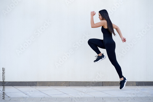 Young woman with fit body jumping and running