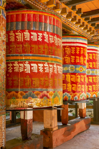 Vertical view of colorful buddhist prayer mills in Gom Kora or Gomphu Kora temple near Trashigang, eastern Bhutan