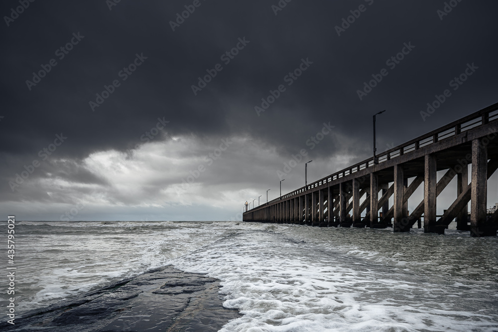 Pier in the sea with thunder clouds