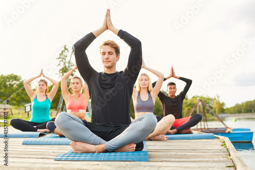 Group of people doing yoga meditation in nature