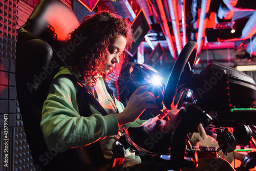 Φωτογραφία african american teenage girl holding vr headset on car racing simulator