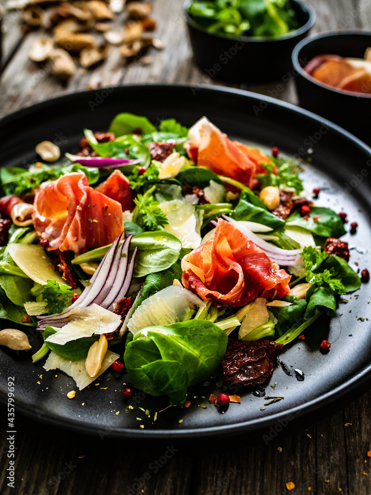 Tasty salad - ham, parmesan and fresh vegetables on wooden background
Tasty salad - ham, parmesan and fresh vegetables on wooden background