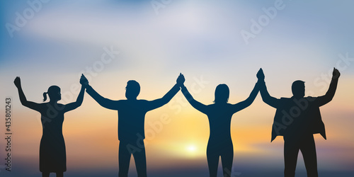 Concept de la solidarité et de la réussite avec quatre personnes qui se donnent la main en signe d’amitié.