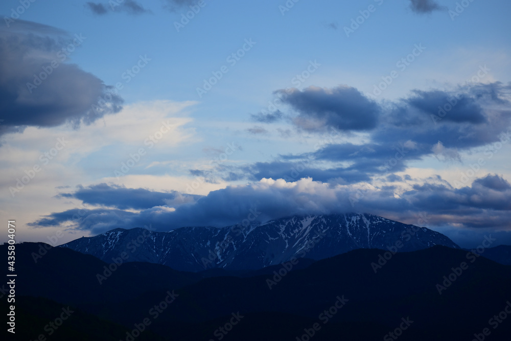 Dramatische Wolken über Schneeberg in Niederösterreich, Österreich, beschneiter Berg mit blauem Himmel