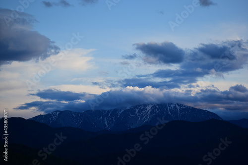 Dramatische Wolken über Schneeberg in Niederösterreich, Österreich, beschneiter Berg mit blauem Himmel © EvaRuth