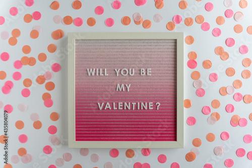 Pink Board Words That Spell Will You Be My Valentine?, on a white background with confetti photo