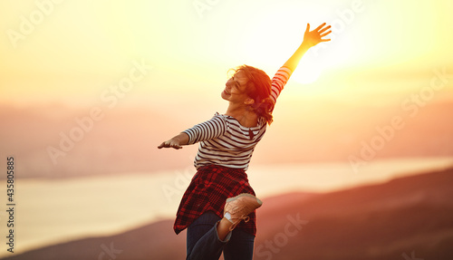 Happy woman dances, jump, rejoices, laughs on sunset in nature