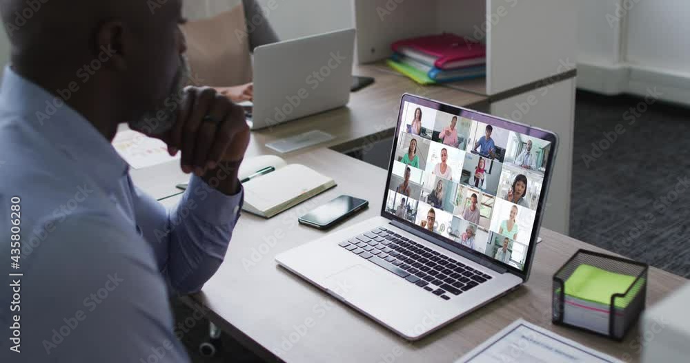 African american senior man having a video conference with colleagues on laptop at office African american senior man having a video conference with colleagues on laptop at office
