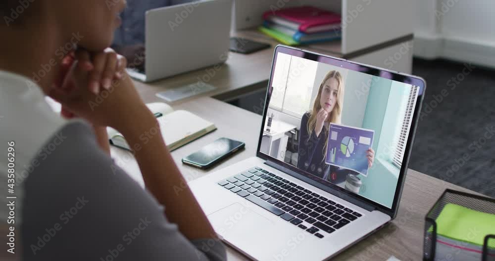 Mid section of african american woman having a video call on laptop with female colleague at office Mid section of african american woman having a video call on laptop with female colleague at office