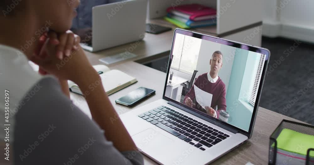 Mid section of african american woman having a video call on laptop with male colleague at office Mid section of african american woman having a video call on laptop with male colleague at office