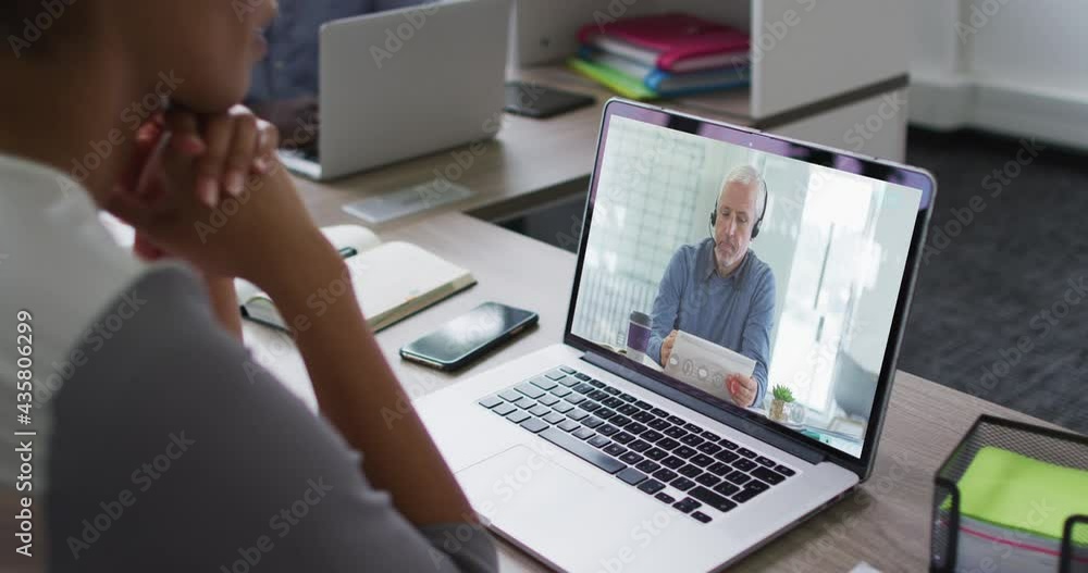 Mid section of african american woman having a video call on laptop with male colleague at office Mid section of african american woman having a video call on laptop with male colleague at office