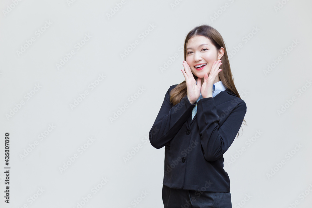 Asian working woman who has long hair wears black formal suit with blue shirt while she smiling happily on white background. Asian working woman who has long hair wears black formal suit with blue shirt while she smiling happily on white background.