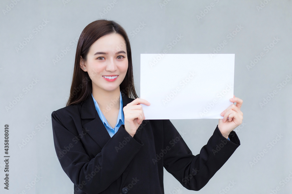 Asian business working female holds plain paper (white paper) to present something. Asian business working female holds plain paper (white paper) to present something.
