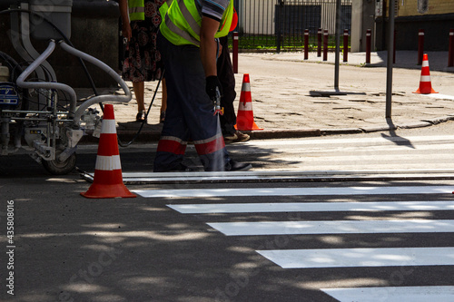 Worker applies road markings, markings for cars