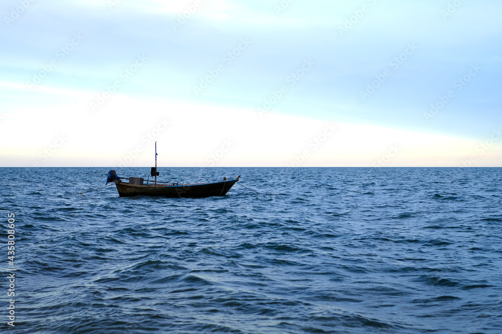 A small fishing boat by the sea in the evening