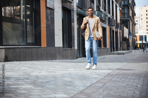 Kind international man keeping laptop in hands